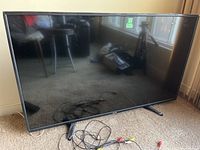 Front view of the Toshiba 49-inch LCD TV with AV cables on the floor