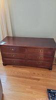 Front view of the cedar chest showing faux drawers on top and real large bottom drawer with damage to drawer edges and peeling on top surface.