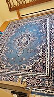Full view of country blue medallion area rug laid flat on hardwood floor