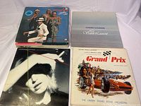 Top view of six vinyl record album covers arranged side by side showing Grand Prix, Boney M., Le Saint-Laurent, and others.
