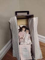 Two collectible dolls in original box wrapped in protective tissue paper with Lullaby documentation shown
