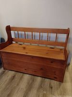 View of wooden hall bench showing hinged flip-top seat and spindle backrest