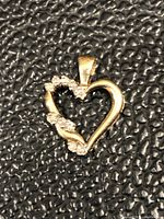 Front view of vintage 10Kt gold heart pendant with diamond accents.
