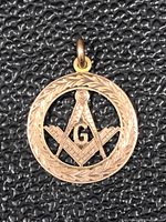 Close-up image of the front of the 10Kt gold Masonic pendant showing the detailed engraving of the circular border and the square and compasses symbol with the 'G' in the center.