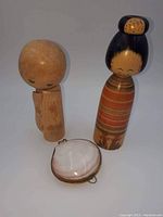 Photo showing both Kokeshi dolls standing and the clam shell trinket box lying in front