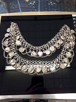 Full view of the vintage belly dancing belt showing two rows of linked metal chains with many hanging coin charms.