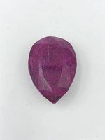 Top view of the large pear-shaped faceted ruby gemstone on white background.