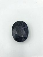 Top and angled views of the oval-cut sapphire gemstone highlighting facets and surface condition.