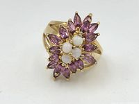 Top-down close-up view of the vintage gold-tone sterling silver ring with a cluster of marquise pink gemstones and round white gemstones.