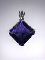 Front view of square purple gemstone in sterling silver setting with decorative bail.