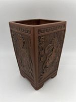 Photo of square Yixing vase showing two sides with relief carvings of traditional Four Beauties and Greek key patterned border at the top