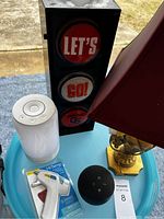 Photo showing Oregon State decorative item, white LED light device, hot glue gun in package, brass decorative lamp, Amazon Echo Dot, and a MaxSold lot tag 8.
