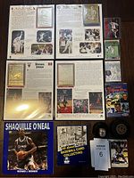 Grid of autographed sports cards and memorabilia including Brett Hull, Mark McGwire, Sammy Sosa, Michael Jordan cards, and a baseball card collecting book.
