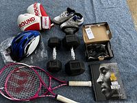 Full lot overview showing boxing gloves, helmet, shoes, weights, tennis racquets, and book