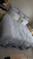King size bed fully made with blue and white bedding and multiple pillows.