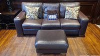 Front view of the brown leather sofa and matching ottoman
