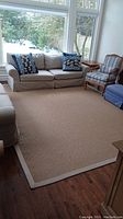Full view of beige sisal area rug under seating arrangement