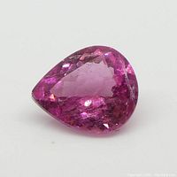 Clear image showing the pear-shaped pink tourmaline gemstone, highlighting its facets and natural inclusions.