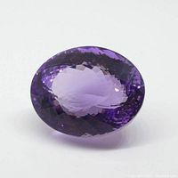 Front view of oval faceted amethyst on white background