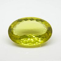 Close-up image of a large yellow lemon citrine gemstone, faceted cut, oval shape