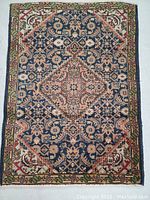 Full view of rectangular Persian Ardebil rug showing detailed central medallion and border patterns.