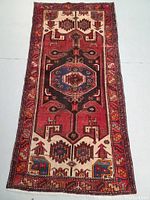 Full length view of red, navy and ivory tribal rug on floor