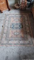 Full view of the Belgium area rug laid flat showing the entire design and size relative to nearby objects