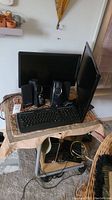 Photo showing two monitors, speakers, and keyboard arranged on top of rolling cart.