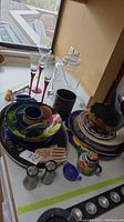 Table display of Ouija tray, assorted platters, plates, decorative bowls, salt and pepper shakers, and small utensils.