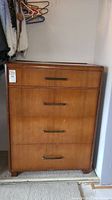 Front view showing four drawers with metal handles and wood finish.
