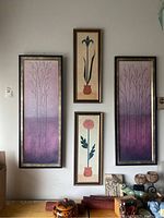 Full view of all four framed art prints arranged on wall above a shelf with decorative items