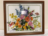 Full view of the framed floral embroidery art piece showing the entire bouquet and the frame.
