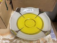 Photo shows glass bowl with yellow center and clear edges from above