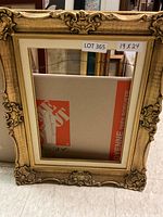 Full view of the ornate gold decorative picture frame sized 19x24 inches, showing the frame standing upright against a floor surface.