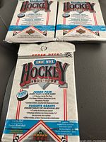 Three unopened 1991-92 Upper Deck LNH-NHL Hockey jumbo wax packs arranged with two behind and one pack in front showing packaging details and branding.