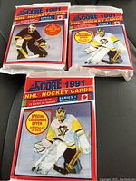 Three sealed 1991 Score NHL Hockey wax card packs from Series 1, showing the front designs with goalie artwork and special offer text.