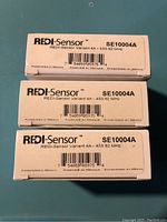 Three boxed REDI-Sensor SE10004A TPMS sensors shown stacked, displaying labels with model number SE10004A and frequency 433.92 MHz.