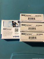 Four REDI-Sensor SE10004A TPMS sensors in original boxes, with visible product labels and packaging.
