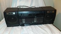 Front view of Sony dual cassette and radio player with removable speakers placed on white cloth background.
