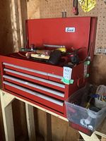 Long shot of red metal toolbox filled with assorted tools.