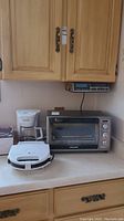 Photo of the White Mountain coffeemaker, Black & Decker toaster oven, and Belgian waffle maker on kitchen counter.