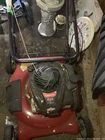 Full top view of the red Canadiana lawn mower showing engine and handlebar.