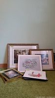Group view of framed and matted prints placed against a wall showing variety of sizes and frame styles