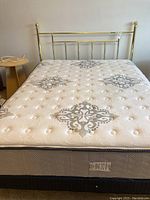 Front view of queen bed set with faux brass headboard, mattress and boxspring