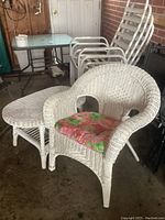 Wicker chair with cushion and matching table visible in a covered patio setting.