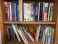 Bookshelf with top shelf featuring programming and technology books including titles on Windows, thinking in C++, design, and software engineering.