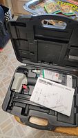 Porter-Cable BN125A brad nailer in original molded black plastic case with manual and oil bottle inside.