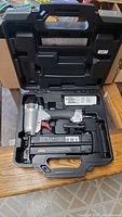 Porter-Cable BN200C brad nailer inside black plastic carrying case on wooden surface