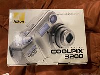 Closed box of Nikon Coolpix 3200 digital camera showing front with branding and product image.