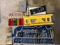 Photo showing assortment of screwdrivers, drill bit set, mitre box, drive tool wrap and Xcelite tool wrap with sockets and wrenches.